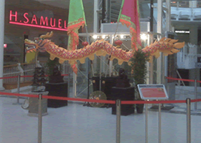 Small display at shooing Centre for Chinese New Year with Dragon, Bamboo plants, Parade Flags,Large Foo Dogs on Plinths and Bircage on Plinth